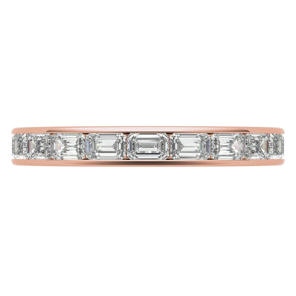Rose gold ring with emerald-cut diamonds on a white background